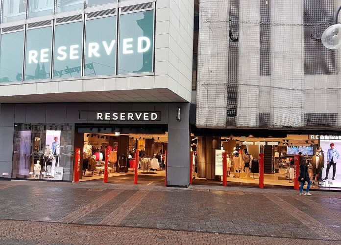 Client Reserved arătând codul QR din aplicație la casa de marcat pentru un retur gratuit