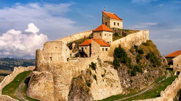 Cetatea Rupea pe dealul de bazalt și zidurile restaurate
