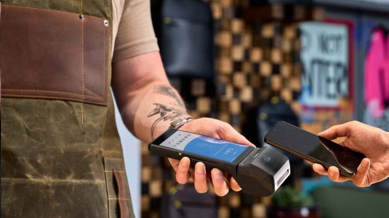 Terminal myPOS Carbon utilizat într-o cafenea pentru plăți contactless, afișând sigla Visa și Mastercard.