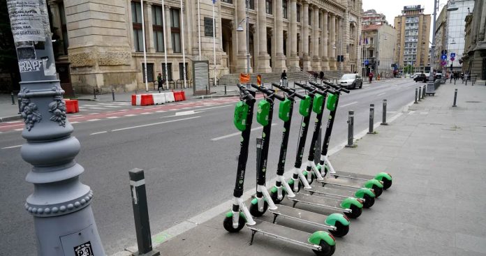 Utilizator contactand suportul tehnic pentru o trotineta electrica Lime parcata pe trotuar