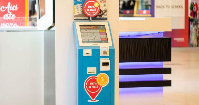 Stație de plată SelfPay în magazin și client sunând la suport