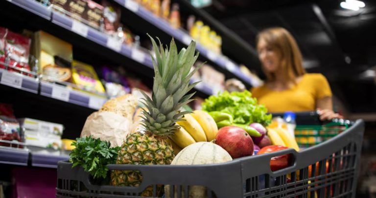 Un client nemulțumit într-un supermarket verificând un bon fiscal și comparându-l cu o etichetă de preț redus de la raft