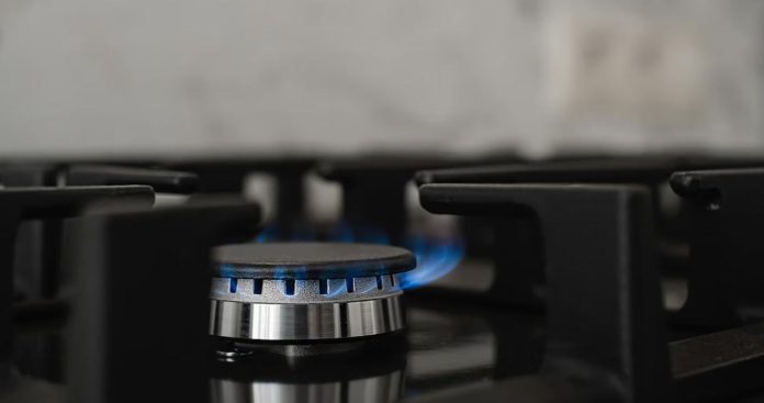 Echipă de instalatori autorizați ANRE montând o țeavă galbenă de gaze și un contor la o casă nouă