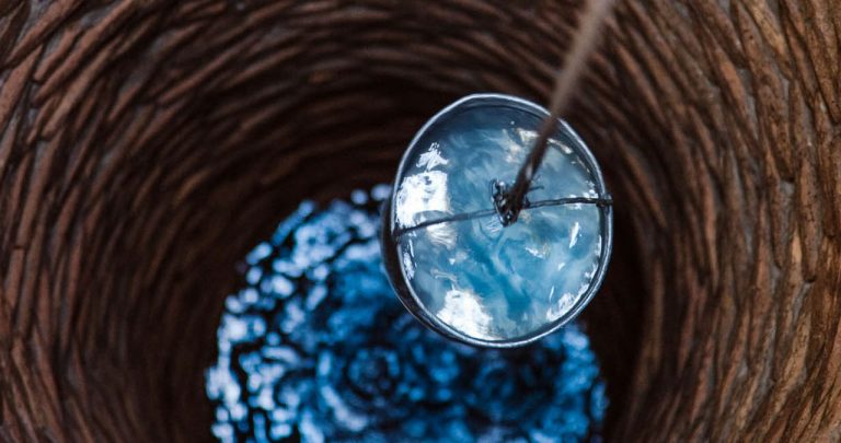 Un utilaj modern de foraj săpând un puț de mare adâncime în curtea unei case aflate în construcție