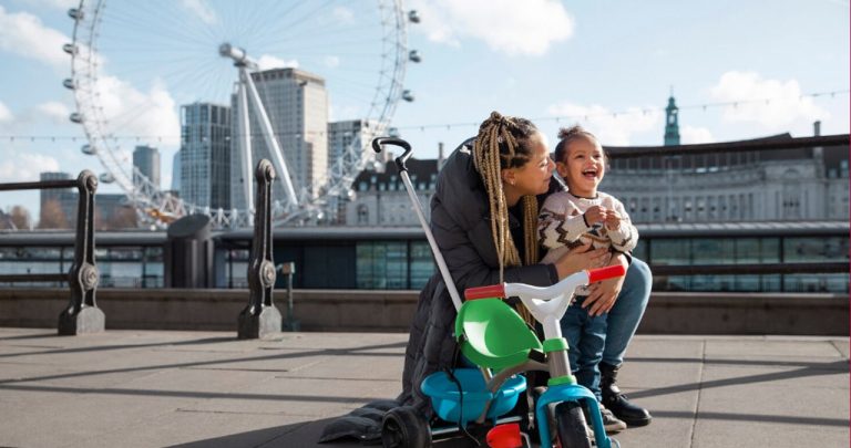 Un ofițer de la poliția de frontieră verificând un pașaport și niște documente notariale înmânate de o mamă care călătorește cu copilul ei