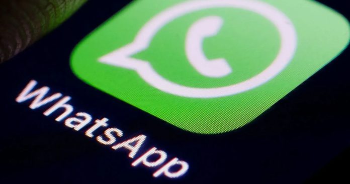 Un utilizator îngrijorat ținând un smartphone care afișează un ecran de avertizare cu numărul de telefon delogat de pe WhatsApp