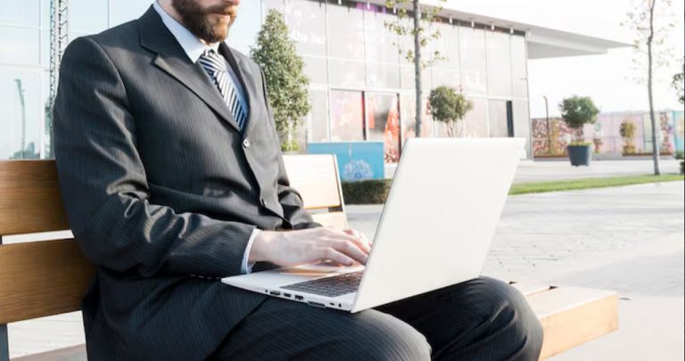 Un client stresat calculând rata pe un laptop lângă un contract de credit ipotecar în Euro și un pix