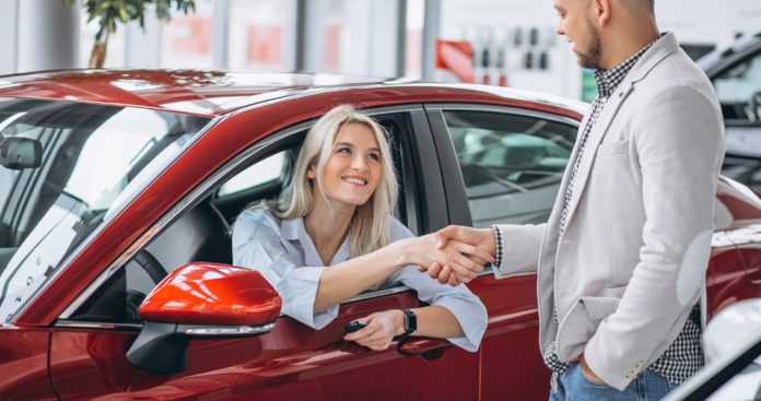 Un cumpărător auto verificând documentele unei mașini pe laptop, tastând seria de șasiu în platforma Registrului Național de Publicitate Mobiliară