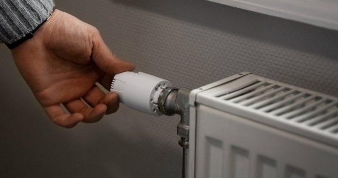 Debransare Termoenergetica RADET acte avize costuri 2026 Un instalator autorizat blindând țevile unui calorifer vechi din fontă, având o mapă cu documente tehnice alături