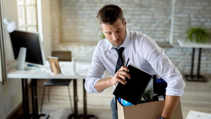 Un angajat completând un formular de notificare a demisiei la birou