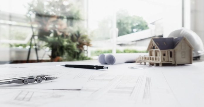 O cutie electrică portocalie de șantier dotată cu prize industriale montată temporar pe un teren în construcție