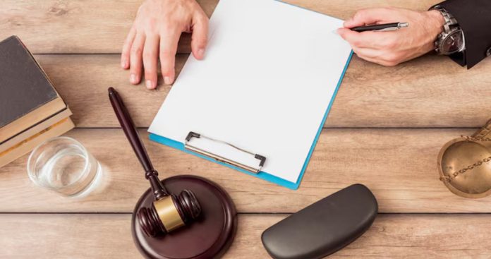 Un ciocan de judecător așezat peste o factură mare de întreținere a unui bloc și un set de chei de apartament