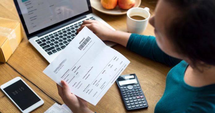 Un utilizator citind un SMS cu notificarea măririi de tarif la abonamentul de telefonie mobilă