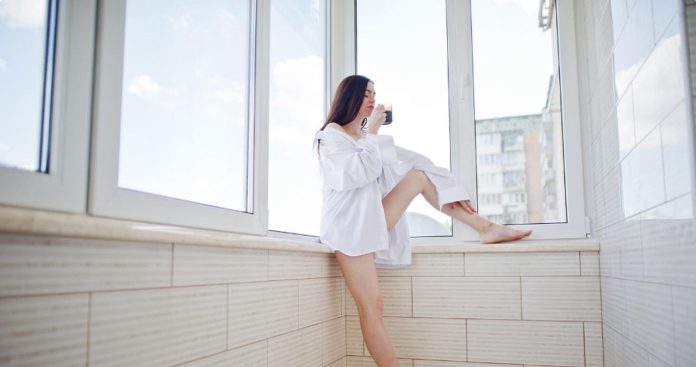 Balcon de apartament proaspăt închis cu geamuri termopan albe aflat la etajul unui bloc rezidențial