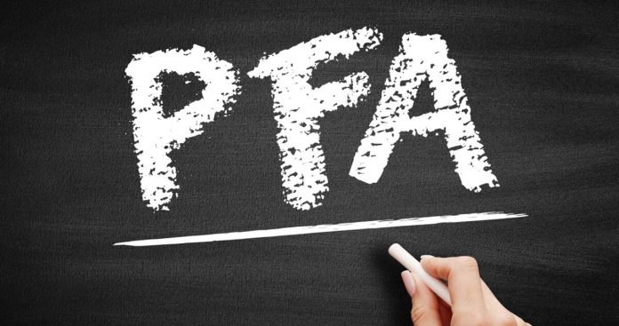 Un antreprenor semnând electronic cererea de radiere a PFA-ului pe un laptop, având alături un dosar cu acte fiscale