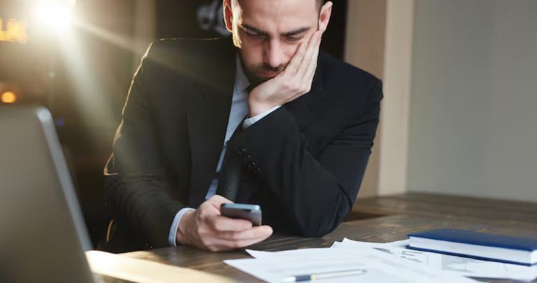 Un antreprenor îngrijorat analizând dosare cu somații de plată de la ANAF la un birou