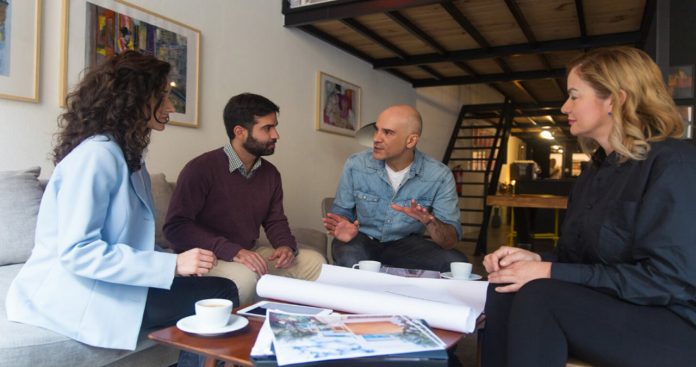 Un grup de locatari semnând documente pe o masă, organizând prima adunare generală a blocului