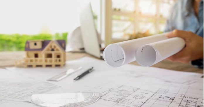 Dosar cu documentație cadastrală și planuri arhitecturale pe un birou