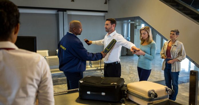 Ofițer al Poliției de Frontieră Române scanând un pașaport la cabina de control vamal dintr-un aeroport