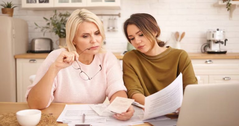 Un părinte verificând documente legale și calculând pensia de întreținere pe un laptop