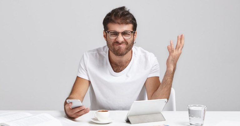 Un angajat epuizat completând un formular online de reclamație ITM la laptop seara târziu la birou