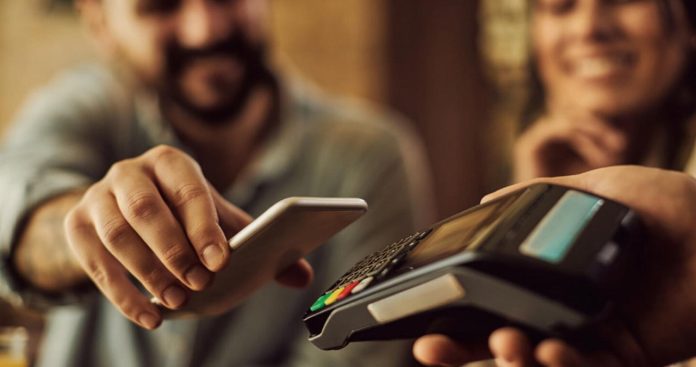 Un terminal POS afișând mesaj de eroare la plată lângă un card bancar și un smartphone deschis pe o aplicație bancară