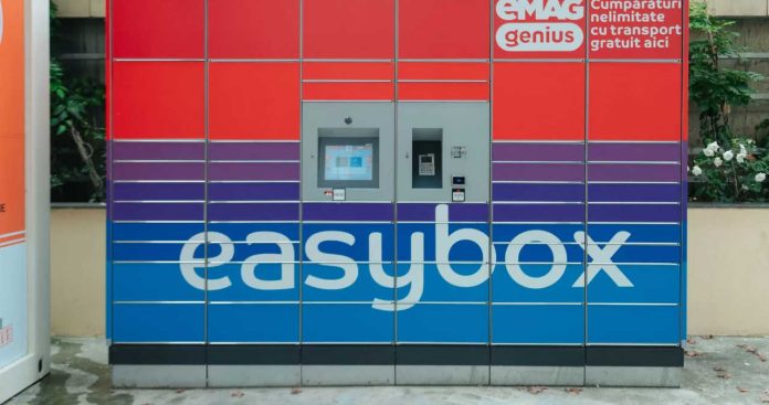 Un client folosind telefonul mobil conectat prin Bluetooth pentru a debloca ușa unui terminal automat de livrare a coletelor