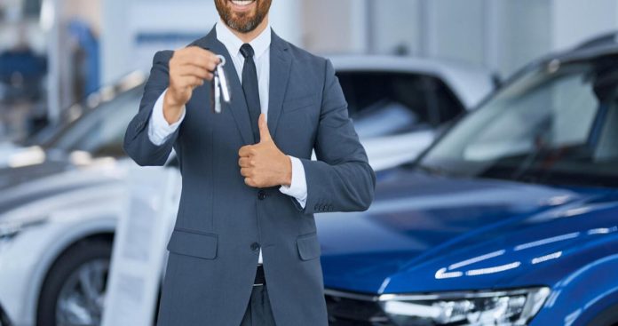 Un șofer semnând o cerere de restituire a primei RCA la biroul unui broker de asigurări auto