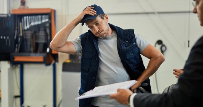 Un angajat semnând un document de suspendare a contractului de muncă la biroul departamentului de Resurse Umane