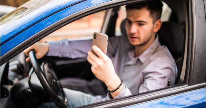 Un șofer folosind telefonul mobil pentru a verifica valabilitatea poliței RCA a unei mașini direct în baza de date AIDA