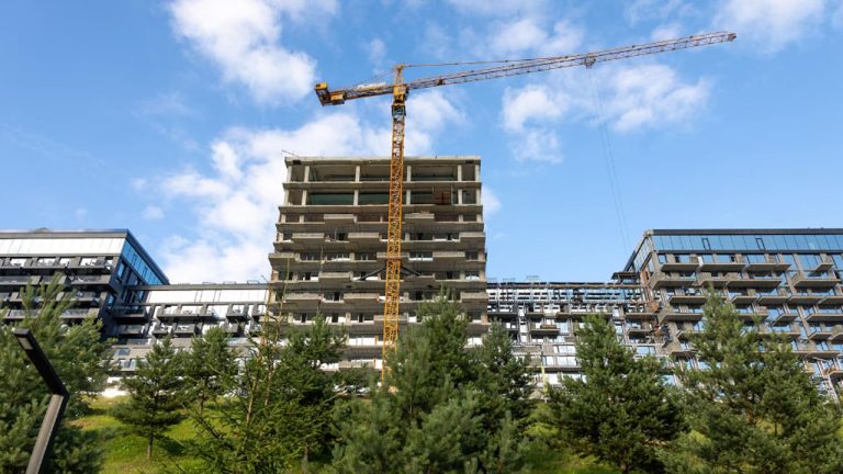 Un șantier de construcții prăfuit lângă o casă rezidențială cu un semn de interzis