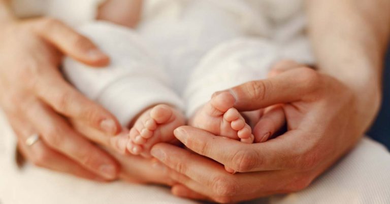 Mamă fericită ținându-și bebelușul nou-născut în brațe, reprezentând momentele în care trimitem mesaje pentru mămici care au născut