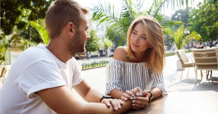 Tineri zâmbind și flirtând la o cafea, reprezentând o conversație începută cu replici de agățat amuzante